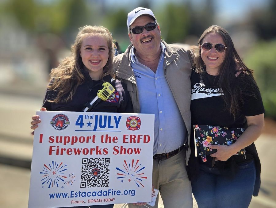 Sean Drinkwine with supporters holding an I support the ERFD Fireworks Show sign on the Fourth of July